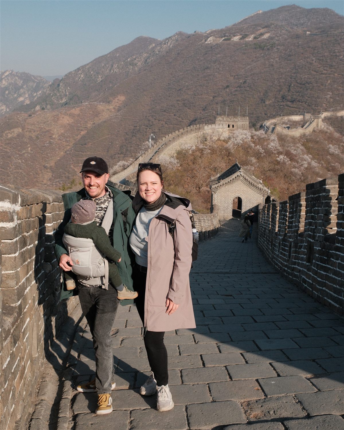 Eva und Basti mit ihrem Kind in der Trage auf der Chinesischen Mauer